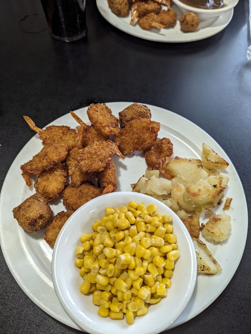 Fried shrimp dinner with corn and home fries